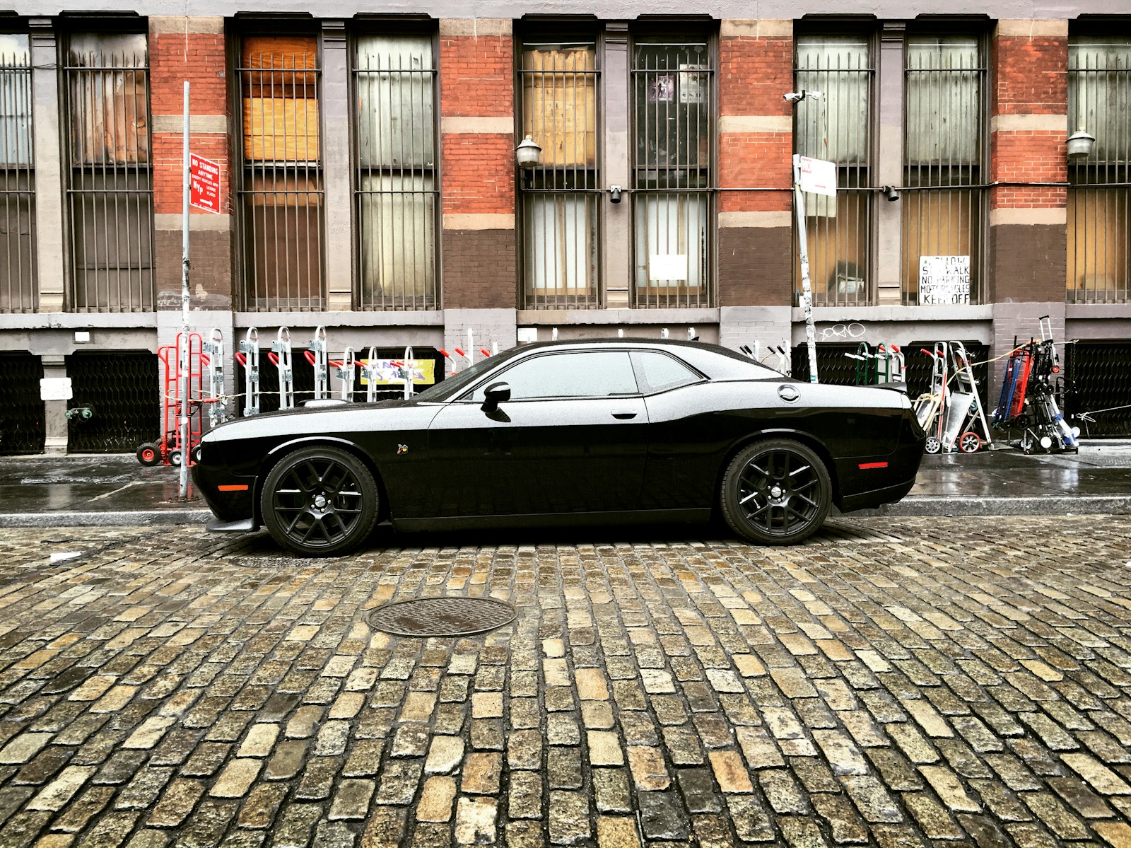 black coupe parked on sidewalk during daytime